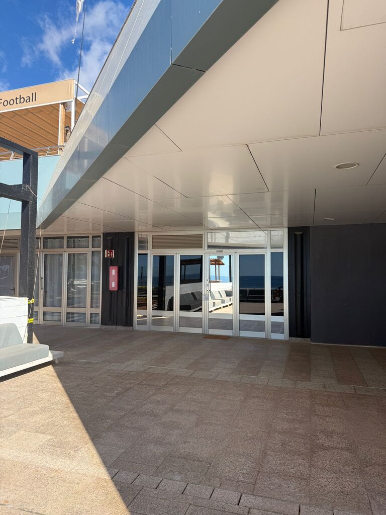 The glass entrance of the club, seen from the walkway of the shopping centre.